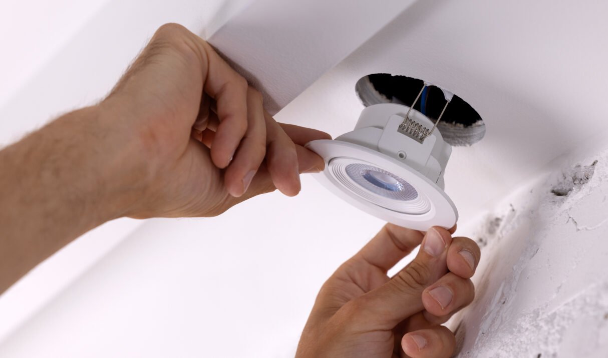 electrician insert recessed lamp in drywall ceiling hole. home led lighting